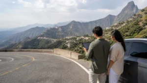 Traveller checking mobile connectivity in the green mountains near Taif.