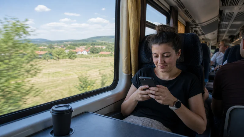 Traveller using a smartphone during romania intercity bus wifi and mobile data guide in Romania.