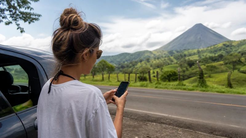 Traveller using a smartphone in Costa Rica for staying online from san josé to la fortuna