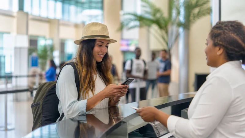 Traveller using a smartphone in Jamaica while buying a SIM card at Sangster International Airport
