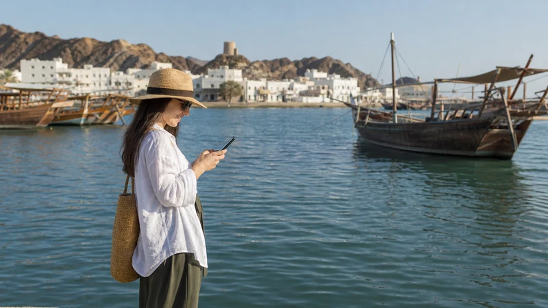 Traveller using a smartphone during visitor on Sur waterfront