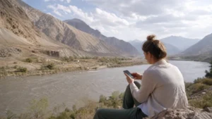 Traveller using a smartphone for tajikistan–afghanistan border mobile internet and esim guide