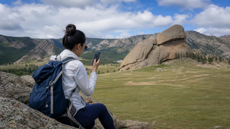 Traveller using a smartphone in Mongolia for terelj mobile internet