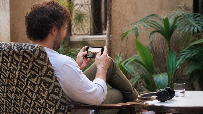 Traveller using mobile data in a Rwanda guesthouse courtyard