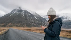 Traveller using a smartphone in Vík