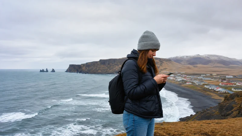 Traveller using a smartphone in Vík