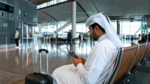 Traveller using a smartphone in Hamad Airport's spacious concourse
