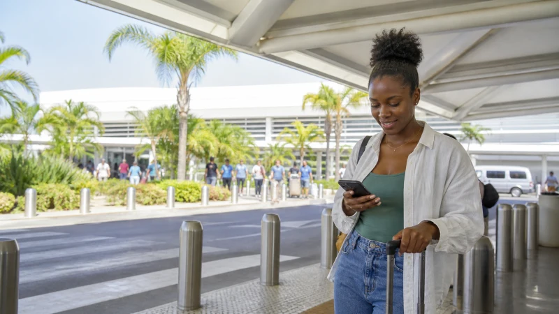 Traveller using a smartphone in Jamaica while using airport Wi-Fi after landing in Montego Bay