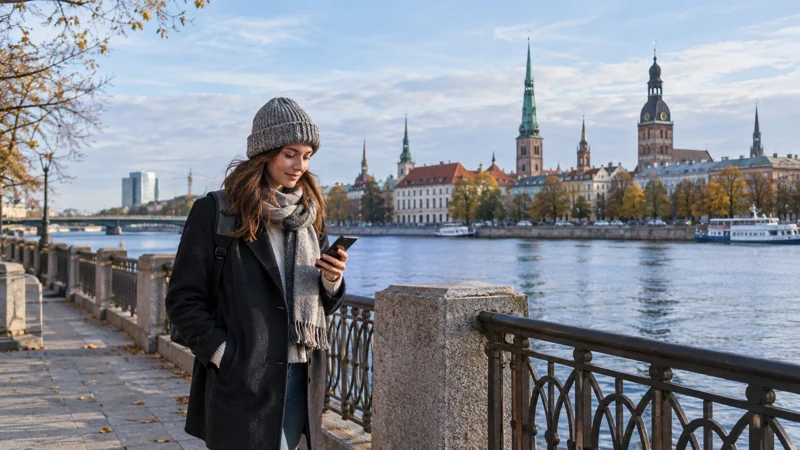 Traveller using a smartphone beside the Daugava in Riga