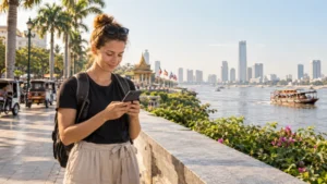 Traveller using a smartphone beside the Phnom Penh riverside