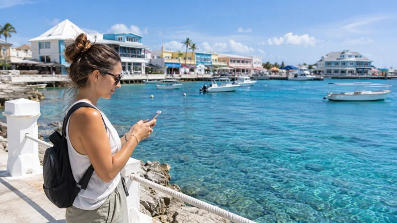 Traveller using a smartphone by a Cayman Islands waterfront