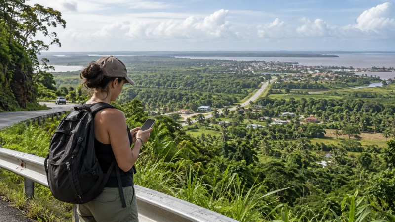Traveller checking a smartphone above Guyana’s coastal plain and rainforest