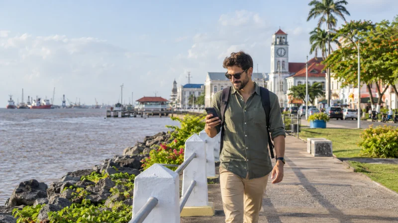 Traveller using a smartphone on the Georgetown waterfront in Guyana