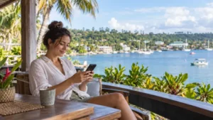 Traveller checking a smartphone on a waterfront terrace in Vanuatu