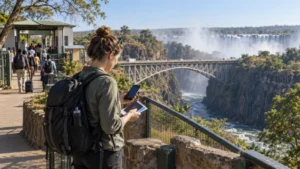 Traveller checking a smartphone near the Victoria Falls border bridge